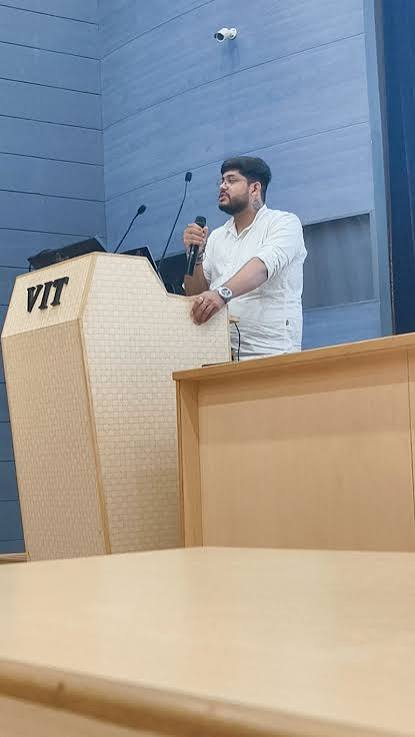 Vastav speaking at a podium